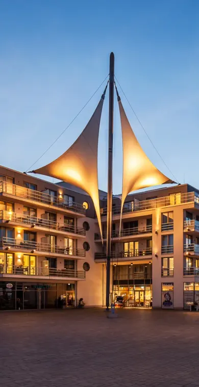 Das Apartmenthaus mit dem großen Segel am Abend